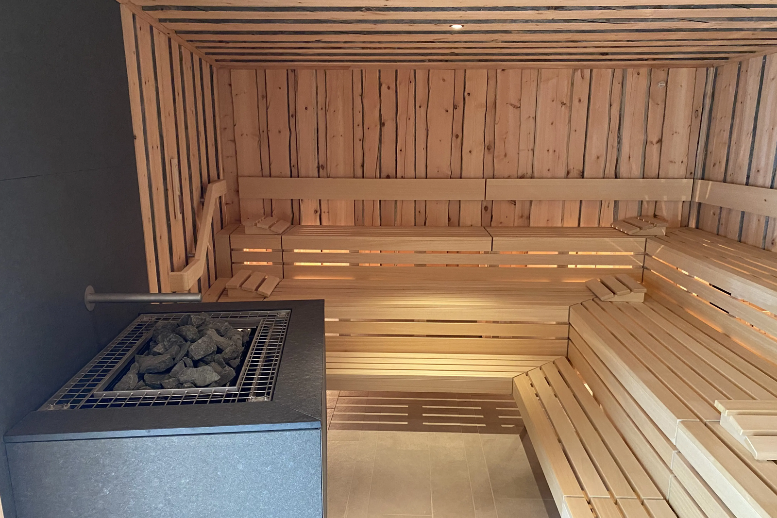 Blick in die Sauna mit Holzbänken und Aufguss-Bereich im Mineralbad Berg.