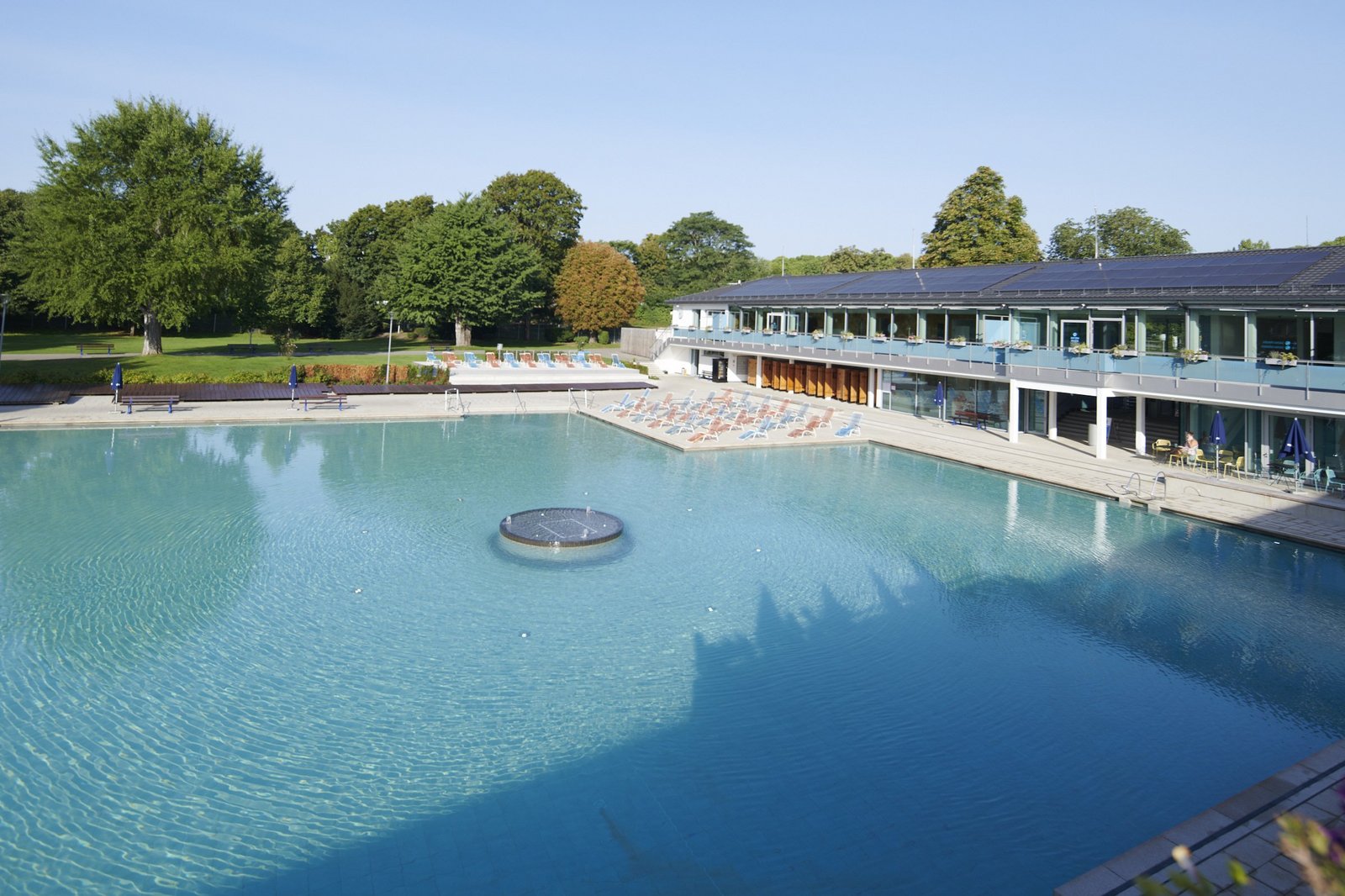 Mineral-Aussenbecken mit Badgebäude inmitten einer Parkanlage im Mineralbad Berg.